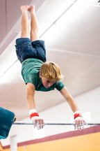 Male gymnast on high bar with Reisport® Men's High Bar Grips - Hook/Loop on hands