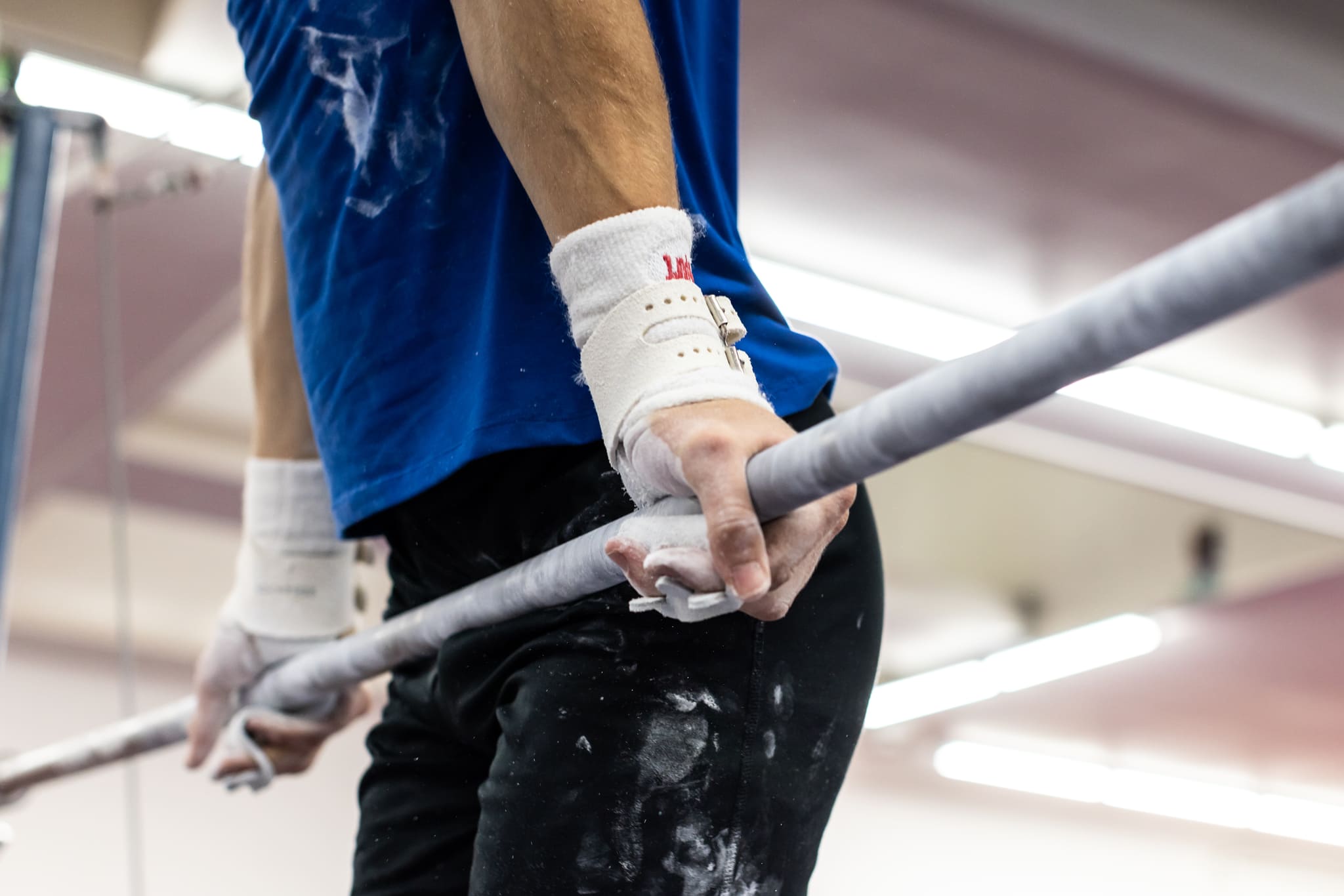 Male gymnast on high bar with Reisport® Men's Hyper Protec High Bar Grips on hands