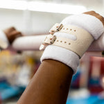 Hands gripping uneven bar with Reisport® Women's Uneven Bar Grips - Double Buckle on