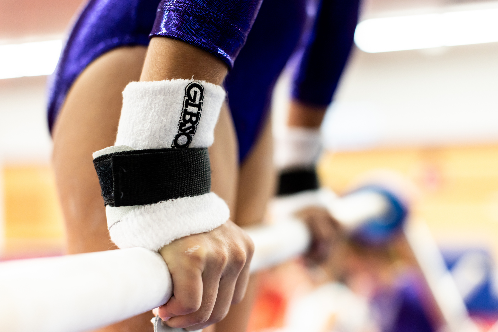 Gibson Just Right Uneven Bar hook and loop grips on hands gripping bar