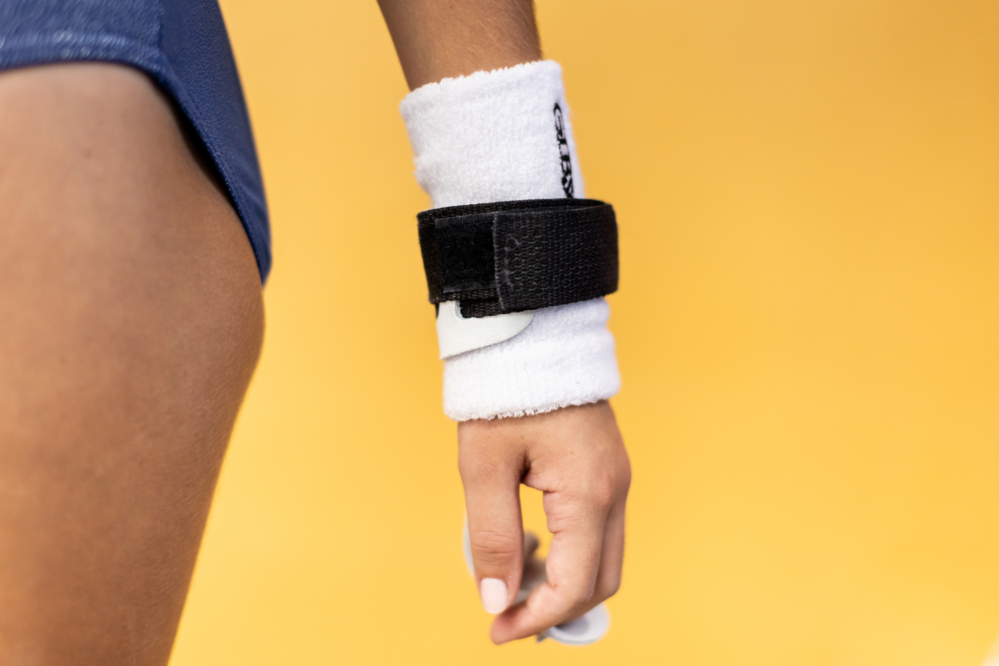 Gibson Just Right Uneven Bar hook and loop grip on hand on yellow background
