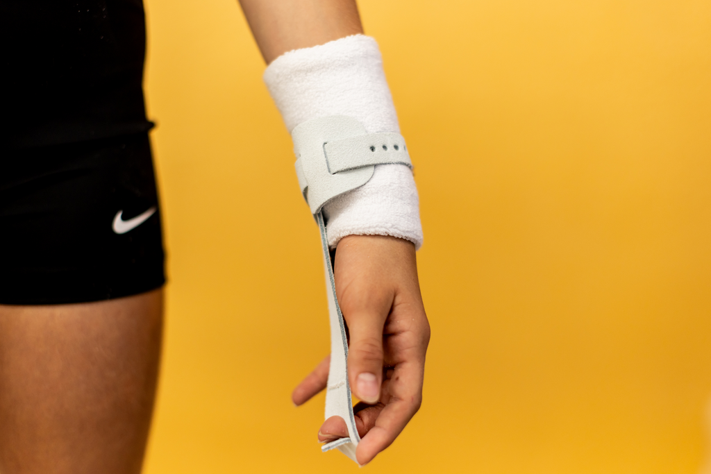 Gibson Just Right Uneven Bar single buckle grip on hand on yellow background