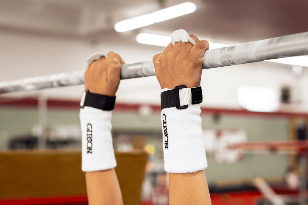 hands with black Gibson Rainbow grips holding bar