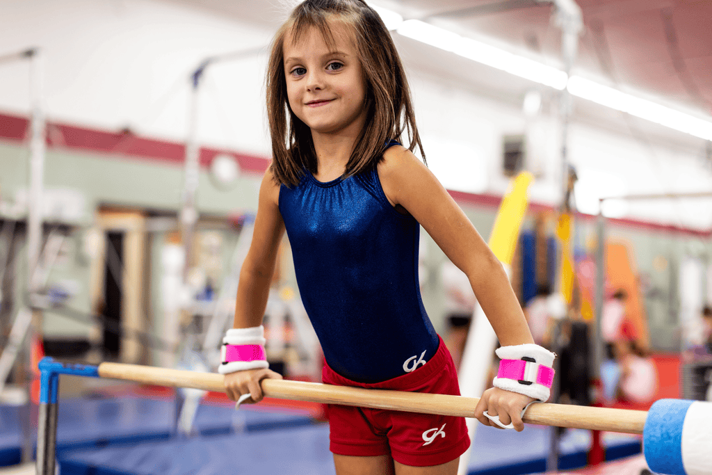 young girl wearing pink Gibson Rainbow grips holding bar