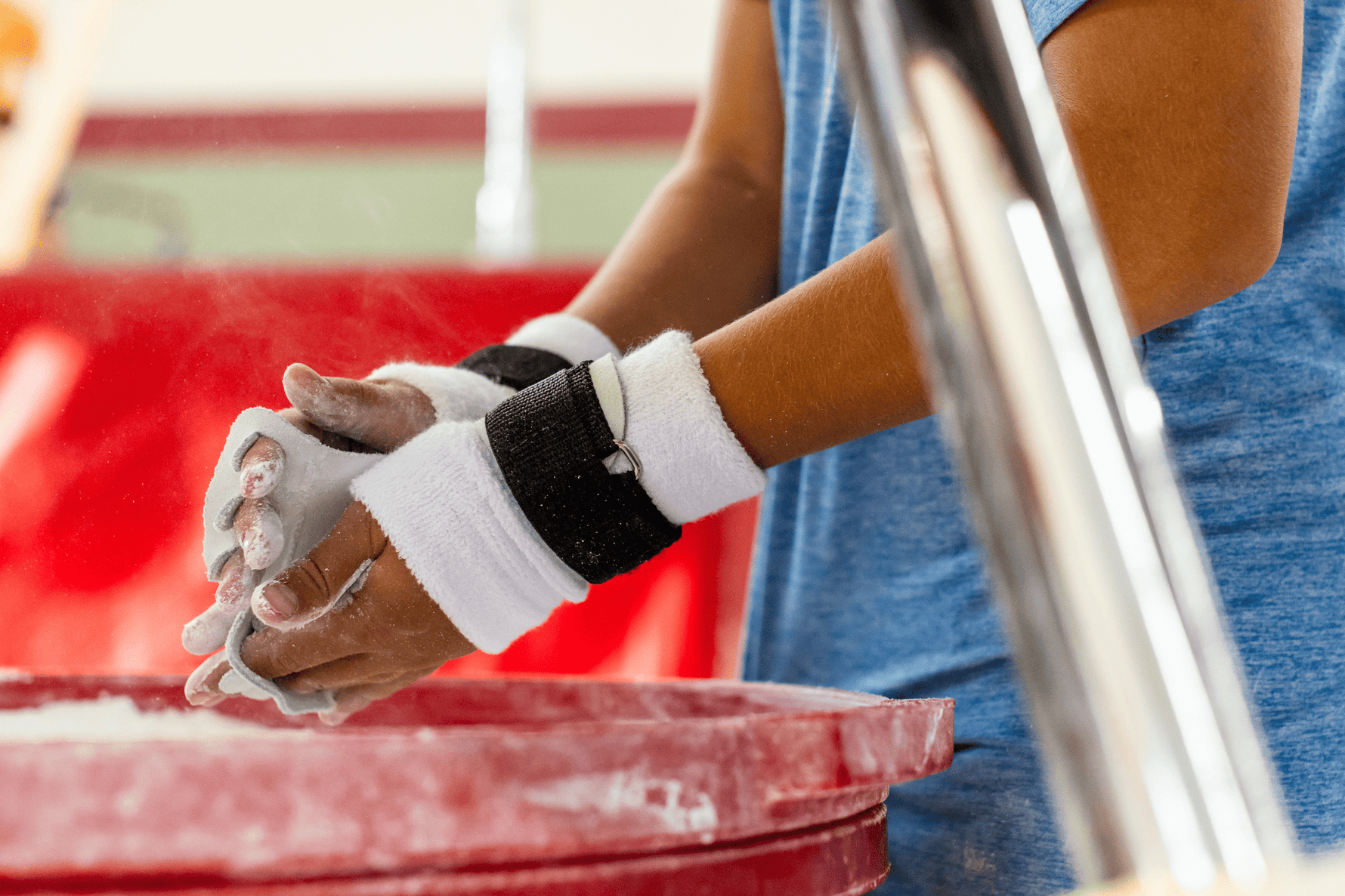 GIbson Summit High Bar hook-and-loop grips on hands using gymnastics chalk