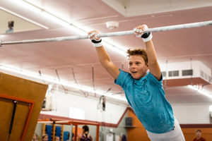 
                  
                    Load image into Gallery viewer, Gibson Summit High Bar hook-and-loop grips on young boy swinging from gymnastics bar
                  
                