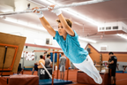 Gibson Summit High Bar double buckle grips on young boy swinging from gymnastics bar